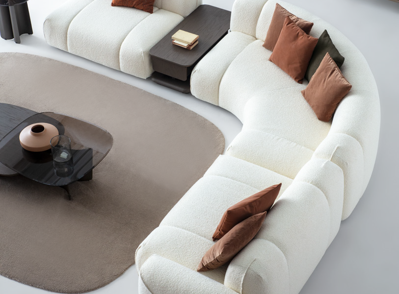 Elegant interior with corner sofa, green chair, and warm neutral tones.