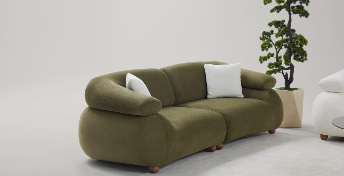 Living area with minimalist sofas, cushioned armchair, and natural décor elements.