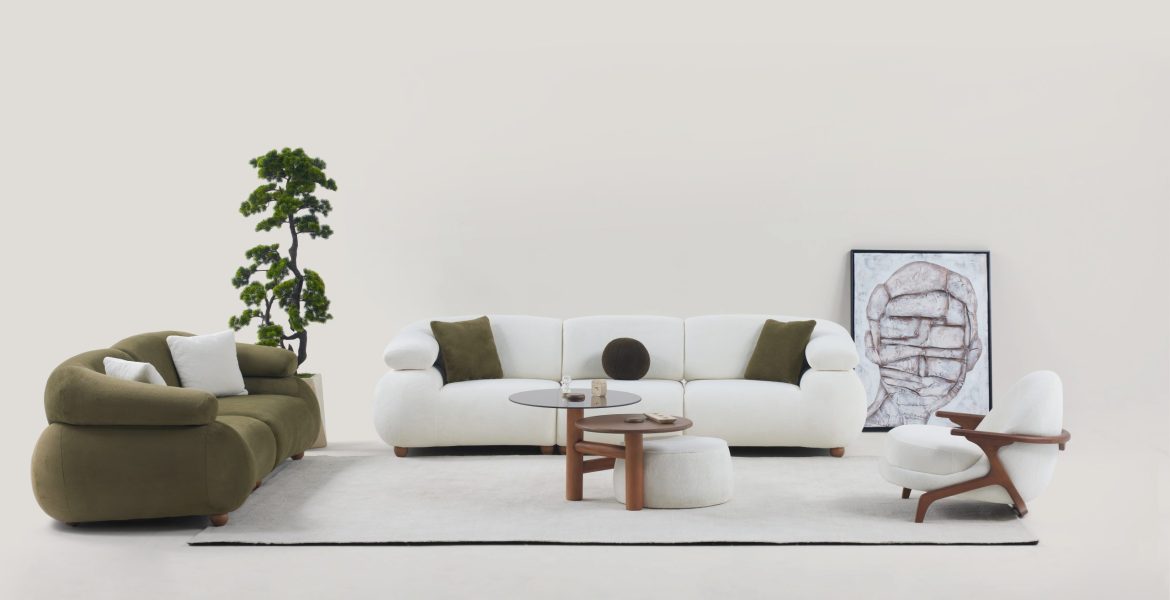 Living area with minimalist sofas, cushioned armchair, and natural décor elements.