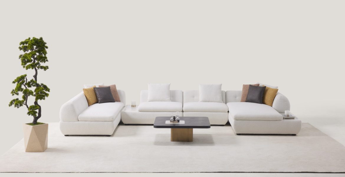 Minimalist space with modular sofa, neutral pillows, and geometric planter.