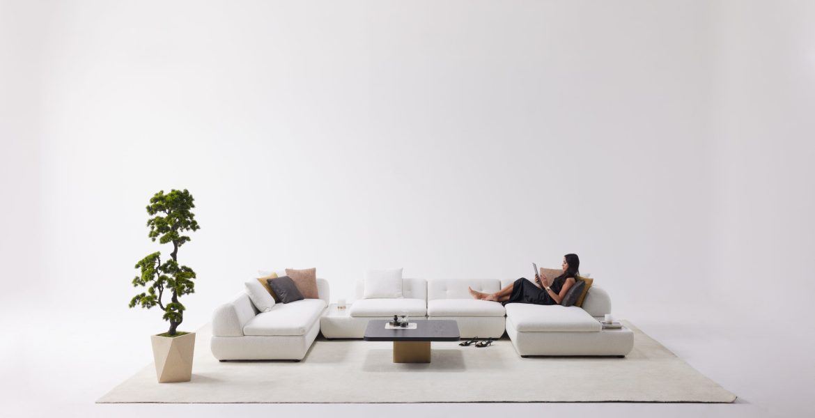 Stylish living area with U‑shaped sofa and modern décor pieces.