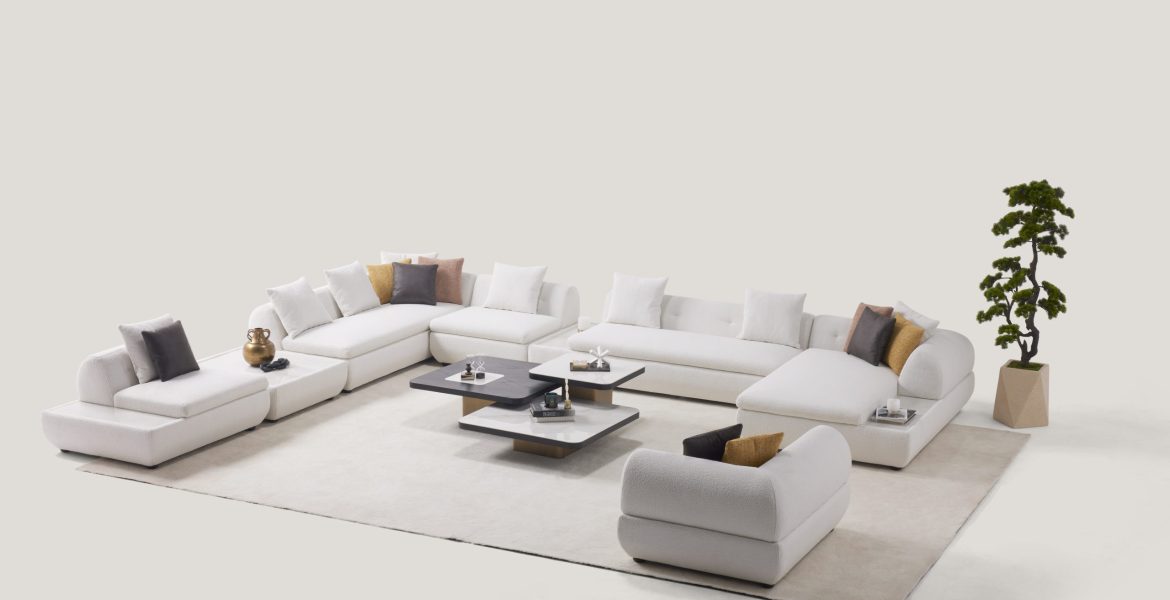 Minimalist room with white sectional sofa and neutral cushions.