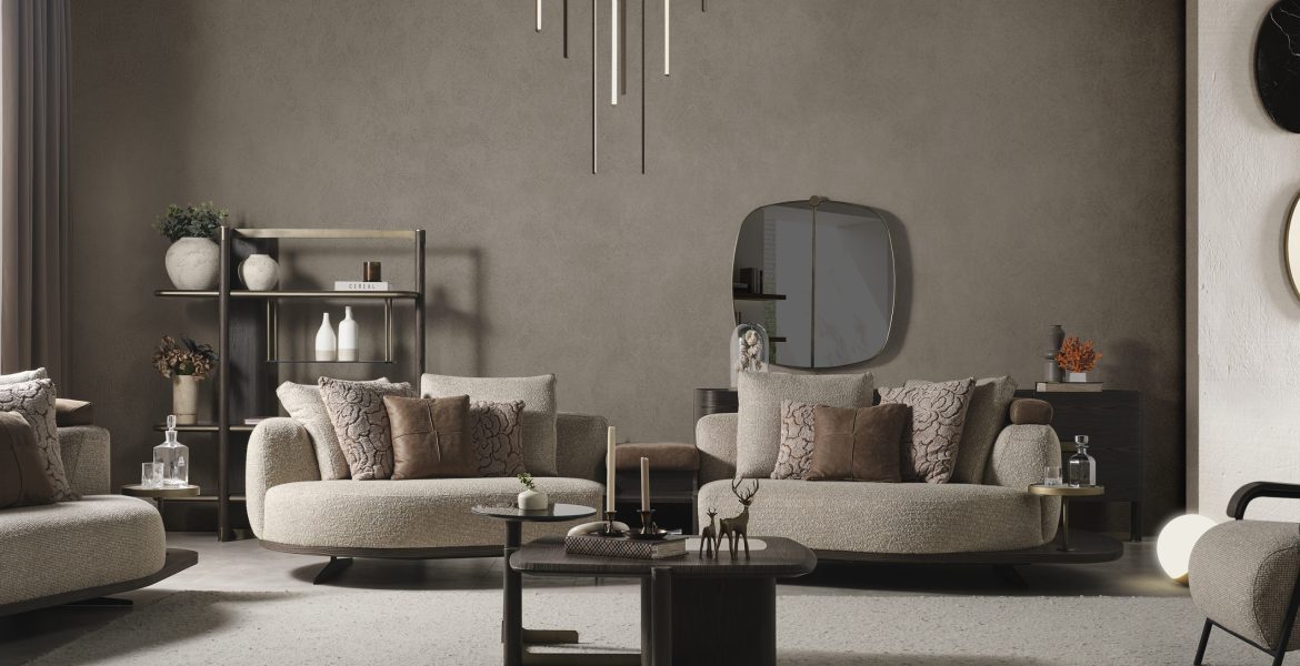 Stylish room showcasing corner sofa, round ottoman, and modern lighting.