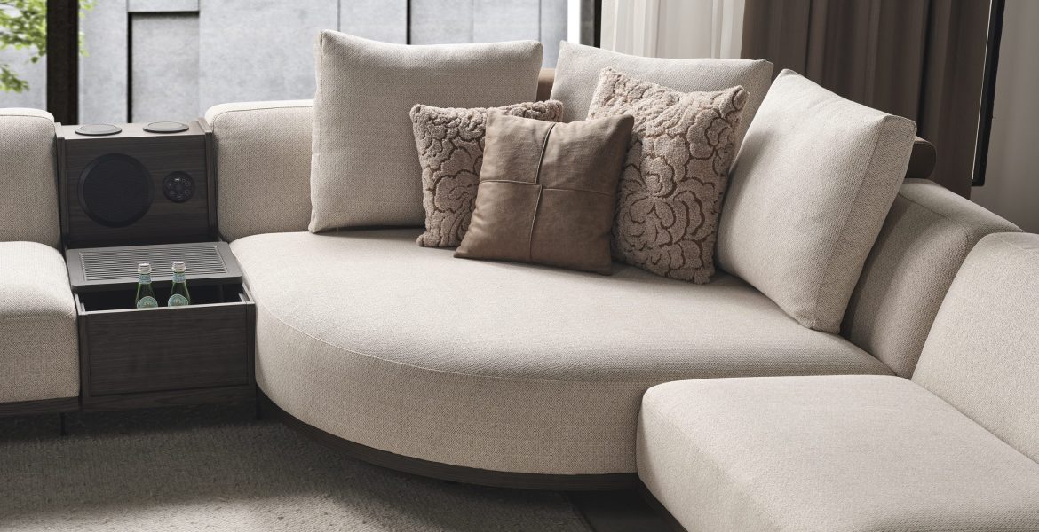 Modern space with sectional sofa, armchair, and large window view.