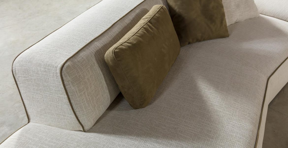 Cream corner sofa with soft cushions.