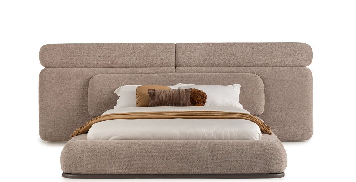 Upholstered bed with rounded headboard and soft beige fabric.