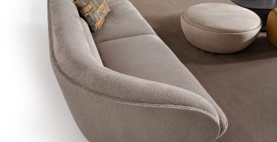 Round ottoman with smooth beige fabric.